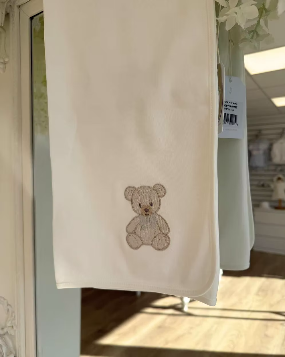 Baby Gi Teddy Shawl featuring soft cotton fabric, embroidered teddy bear detail and available in ivory, pink and blue colourways.
