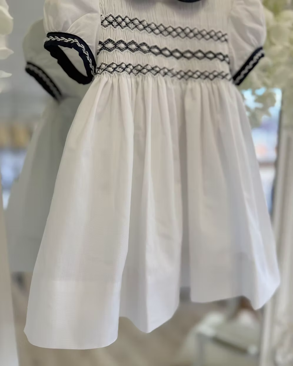 White dress with navy smocking details