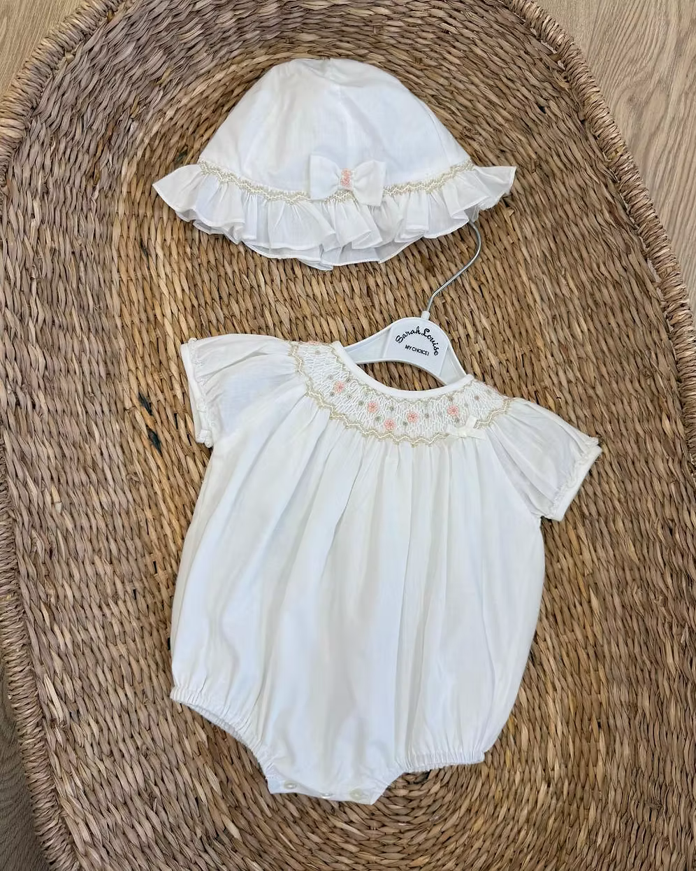 Sarah Louise x Little Lambs Heritage Bubble Romper featuring ivory fabric, hand-smocked floral embroidery, puff sleeves and a classic bubble shape.