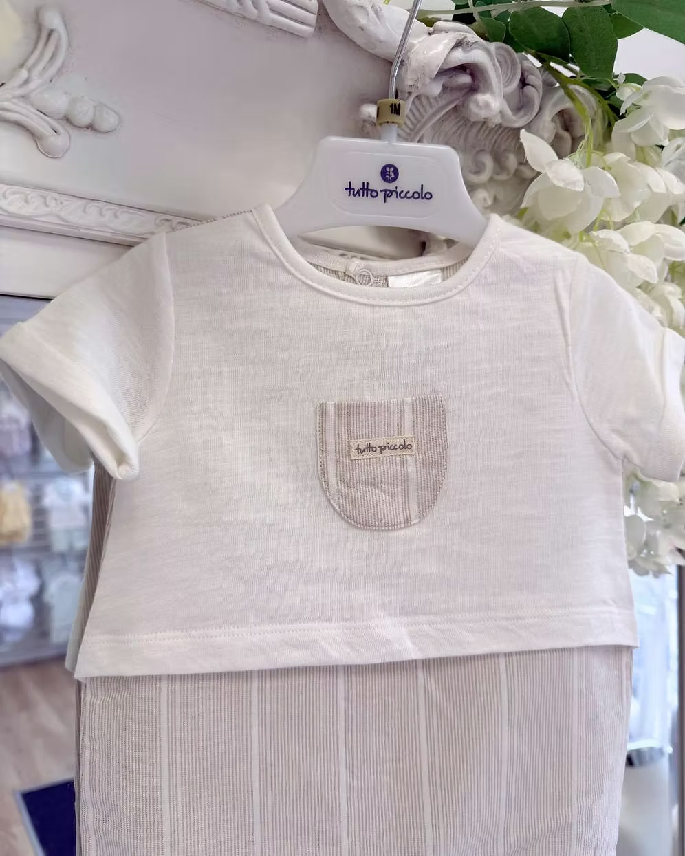 Tutto Piccolo Finn Romper featuring an ivory top, beige striped lower half, chest pocket with embroidered logo and lightweight summer design.