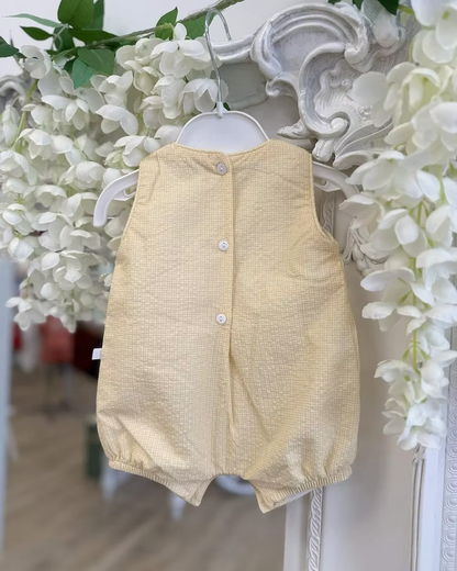 Deolinda Bumble Romper featuring buttery yellow gingham, a smocked chest panel, pleat detailing, button accents and a classic unisex design.