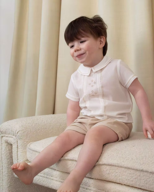 Sarah Louise x Little Lambs Heritage Boys Short Set featuring an ivory shirt with traditional detailing and tailored beige shorts.